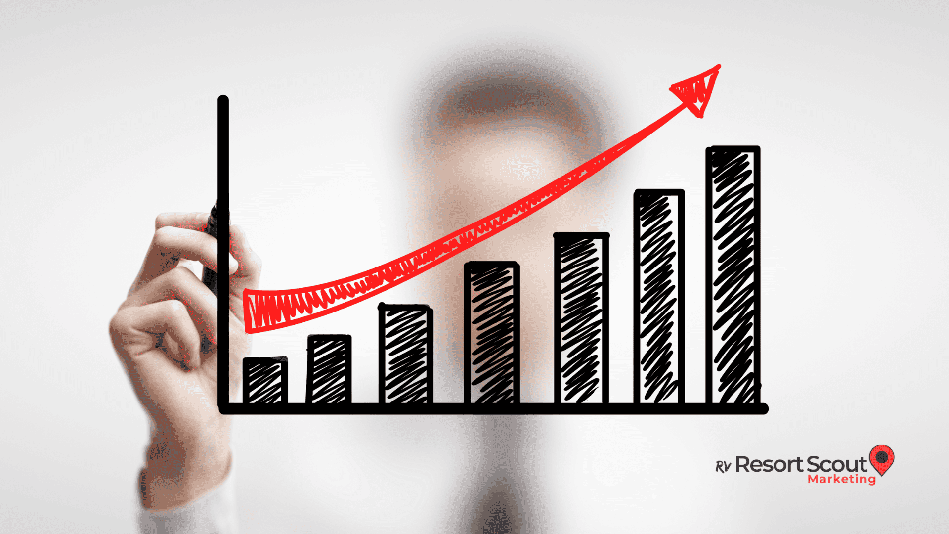 Blurred businessman writing on a clear board as a dynamic bar chart and upward arrow guide strategies on how to increase sales.