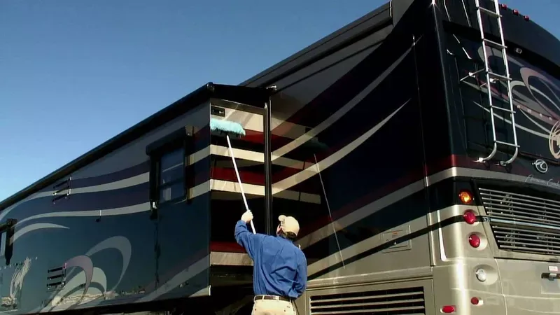 Man washing an RV at a campground.