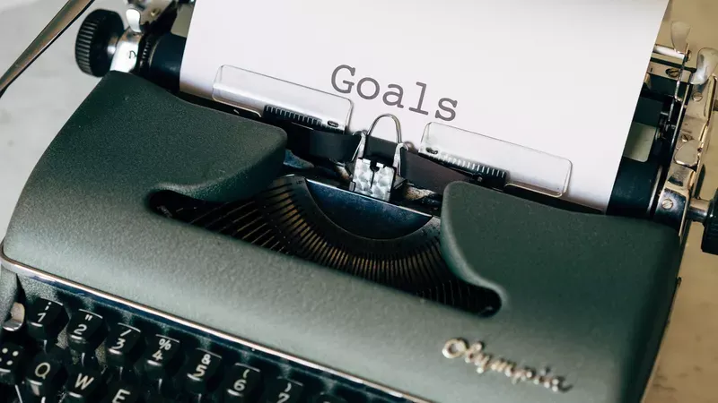 Website Content: Typewriter with Goals type on a white sheet of paper.