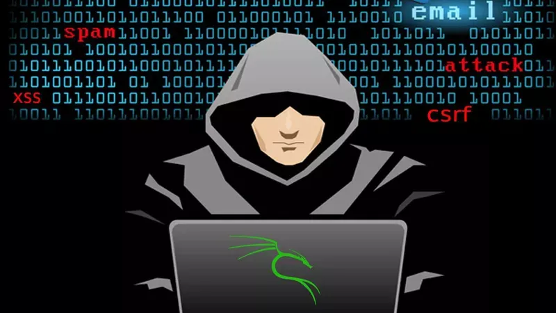 hacker in a grey hoodie o a laptop with binary code in the background.