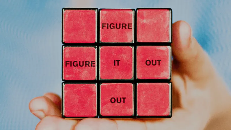 Person holding a solved rubik's cube with the words